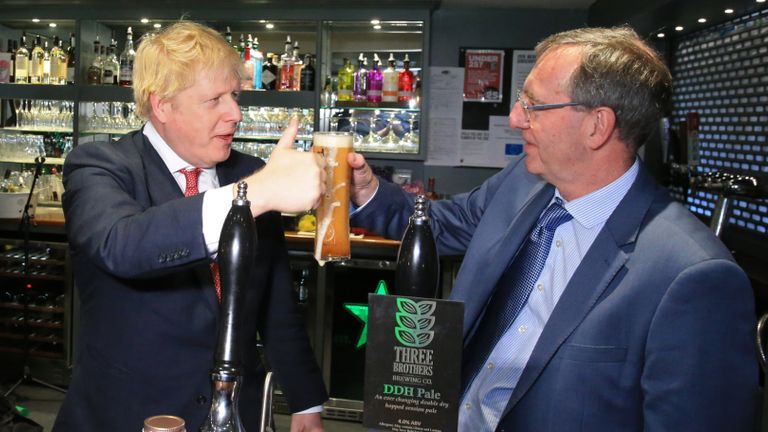 Prime Minister Boris Johnson (left) gestures after pulling a pint with newly elected Conservative party MP for Sedgefield, Paul Howell during a visit to Sedgefield Cricket Club in County Durham.