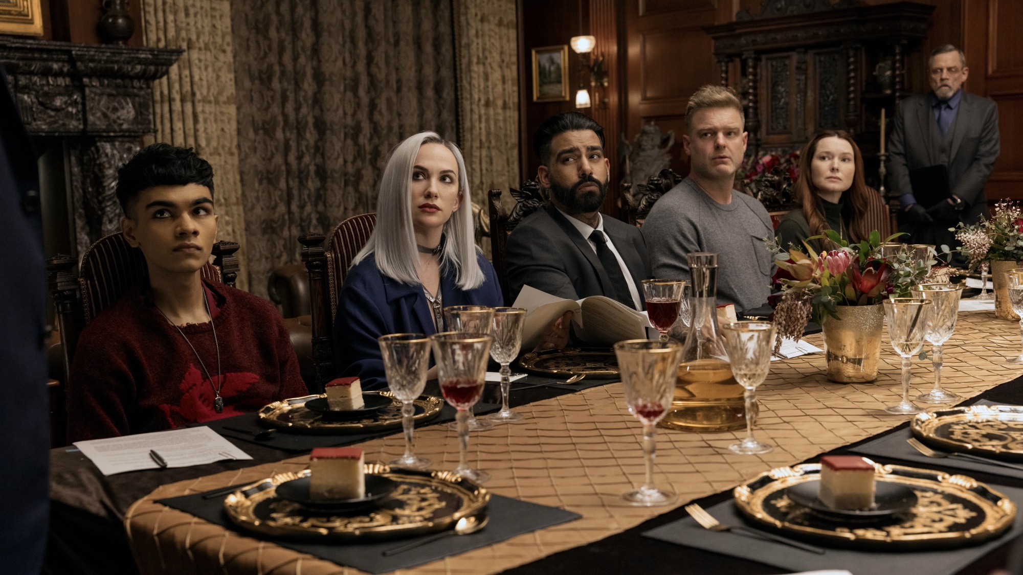 A family seated at a long, lavish dinner table.