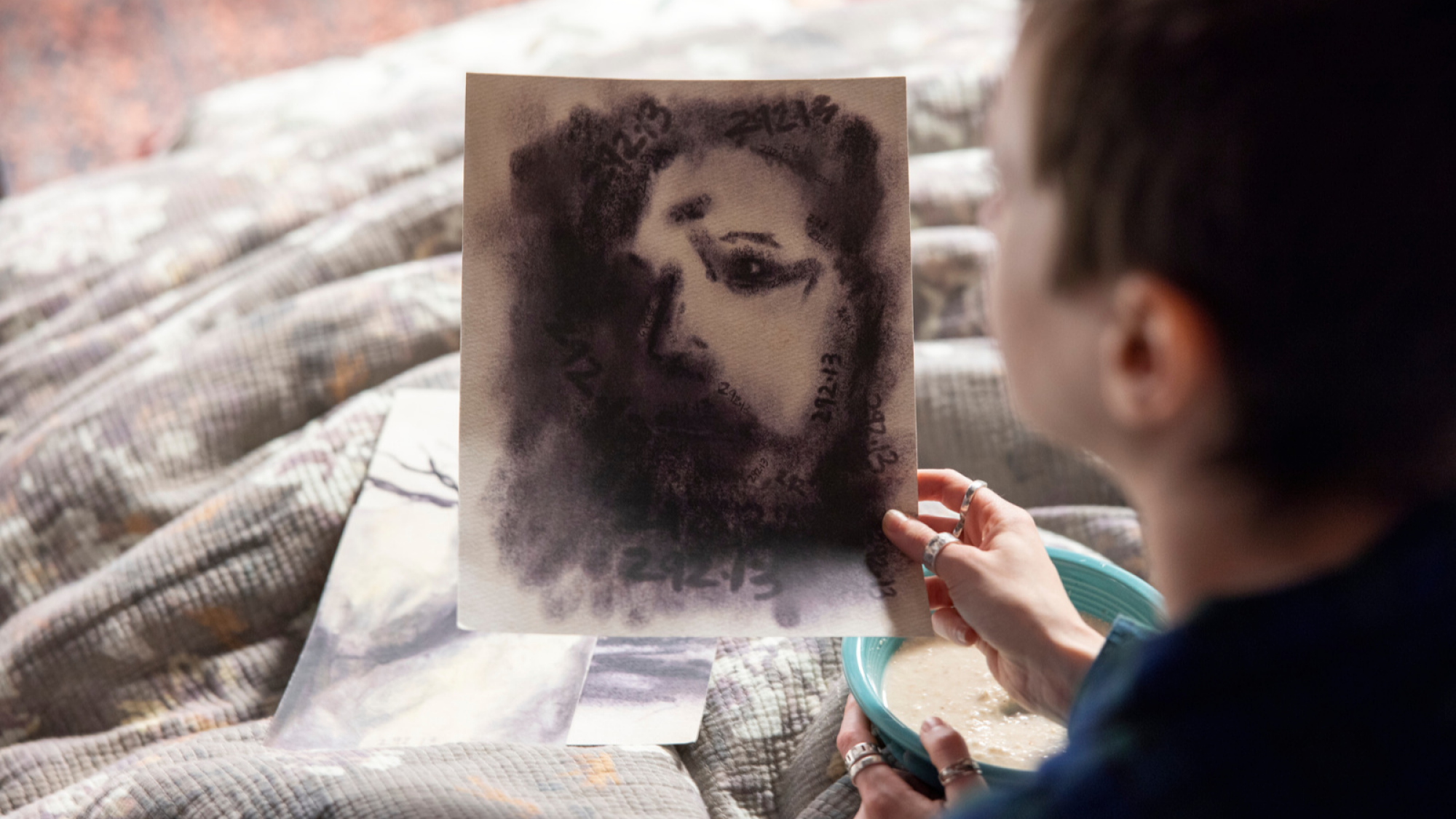 Boy holds a picture of a ghost.