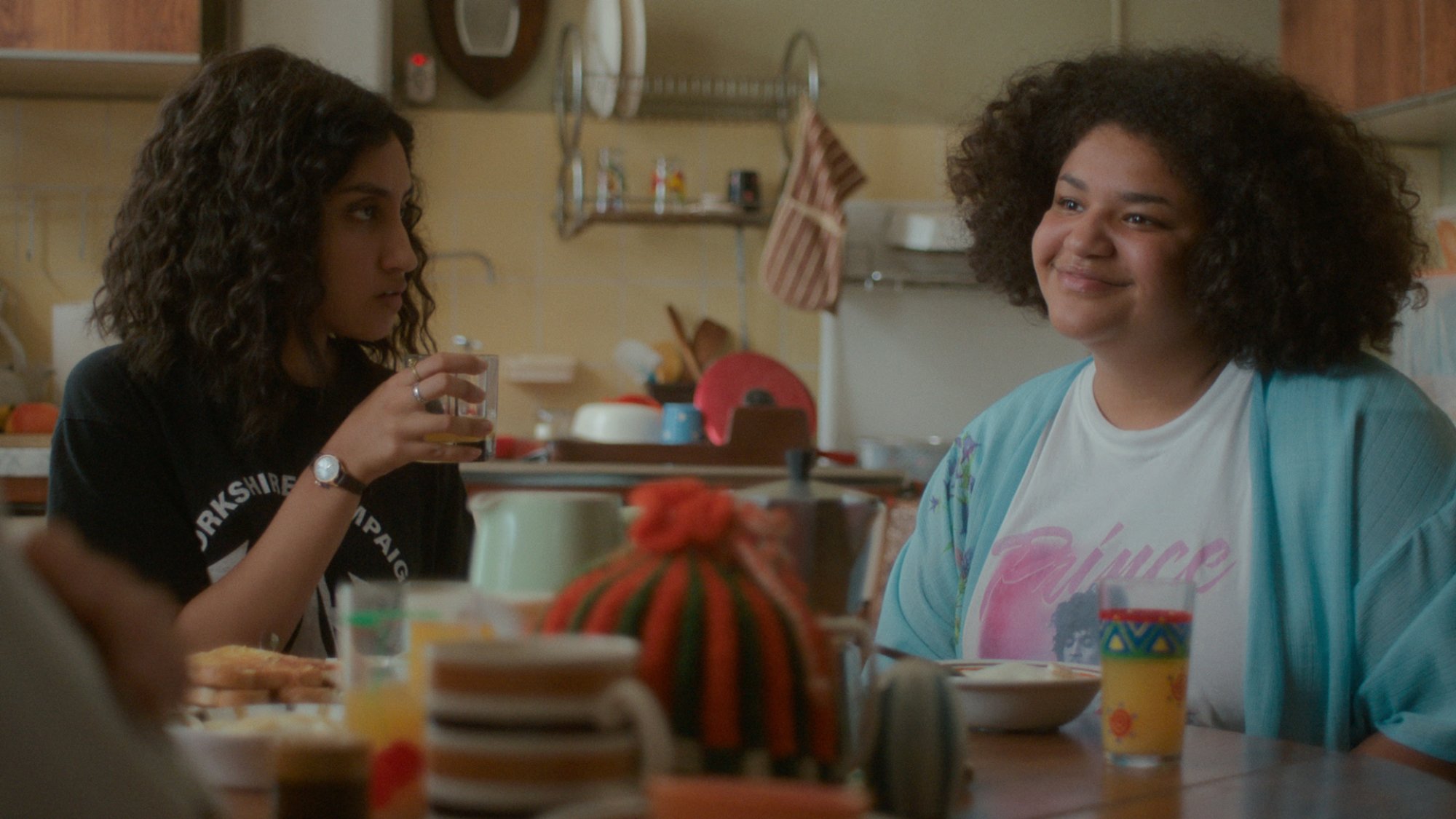 Two uni students sit in their kitchen.