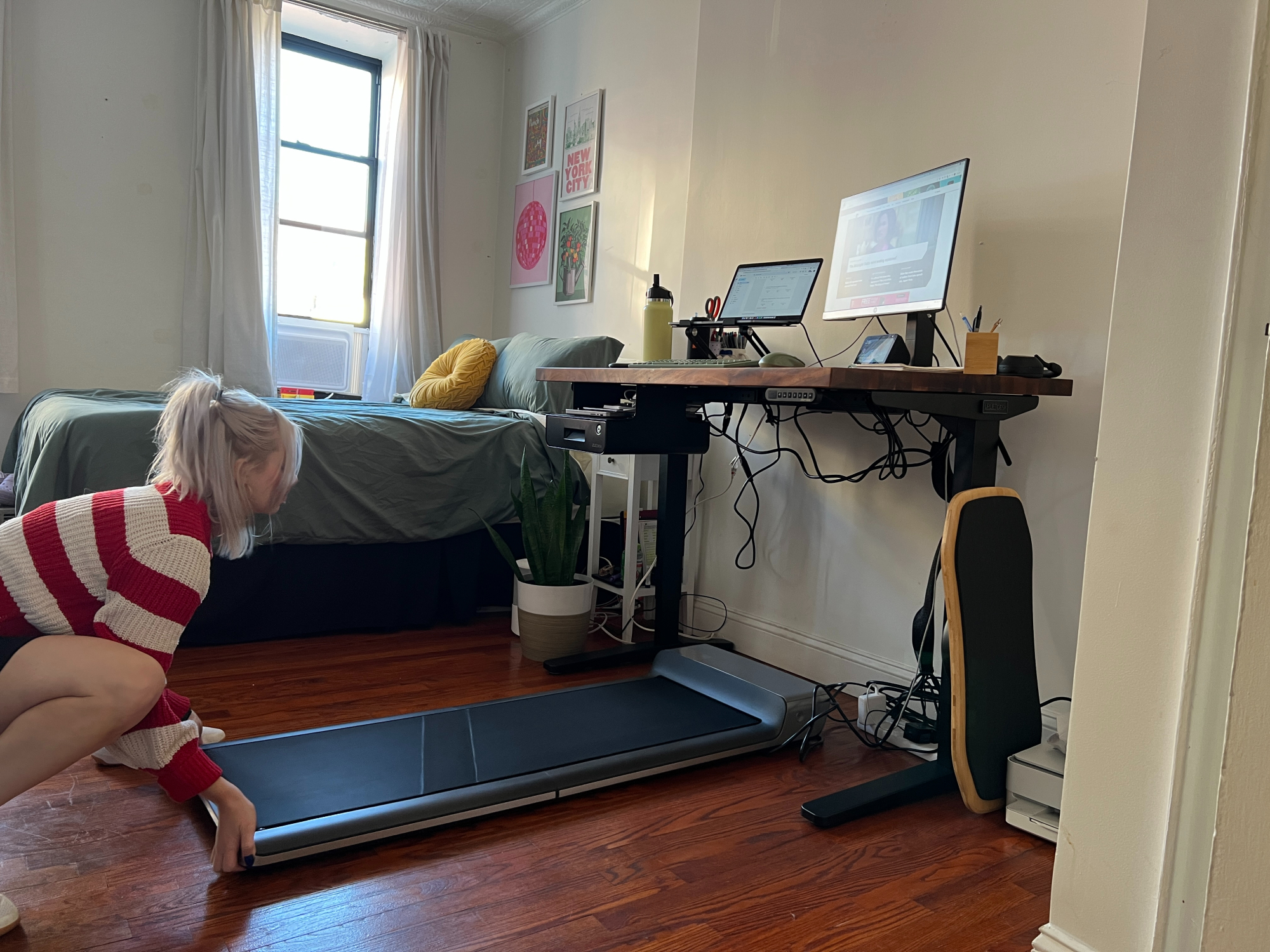 woman pushing a walking pad underneath a desk
