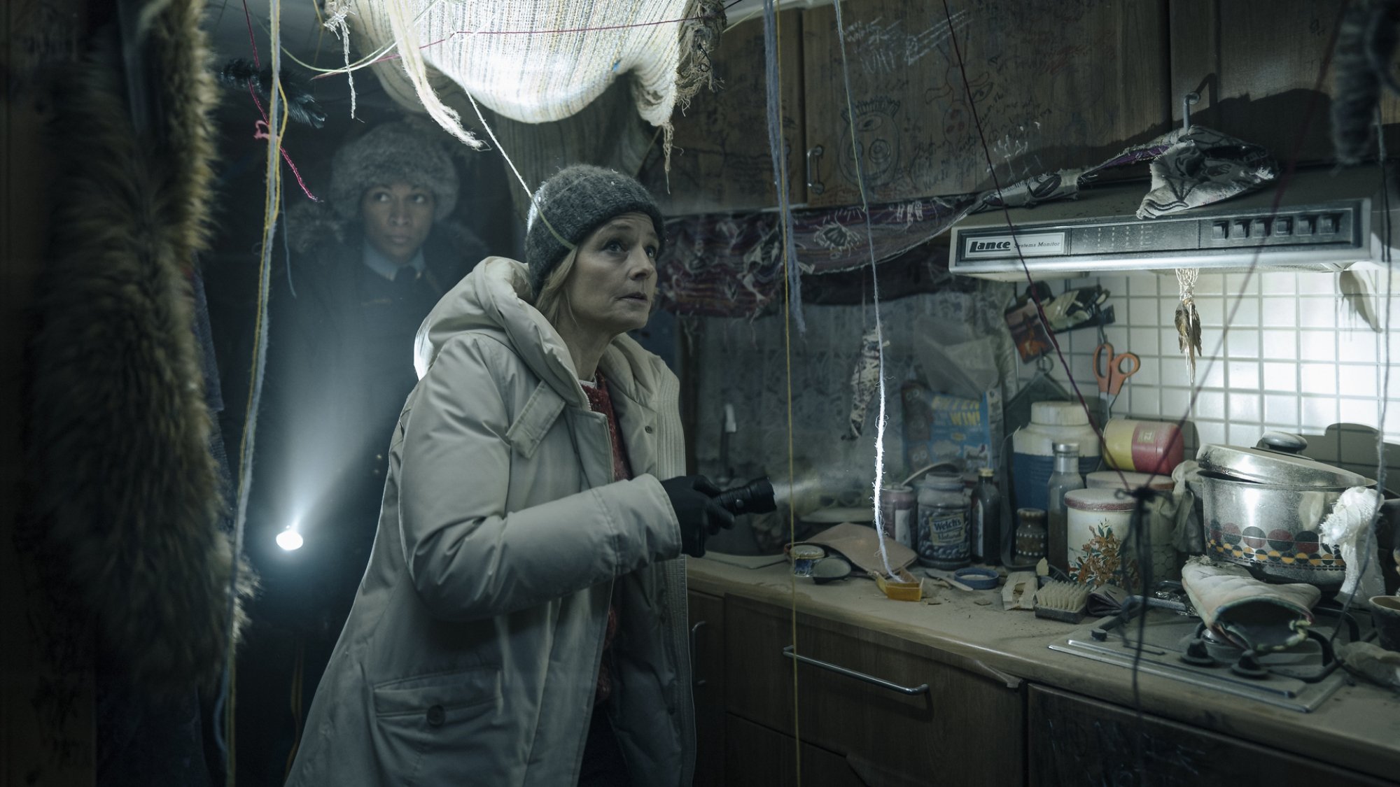 Two detectives enter a very creepy decrepit caravan.