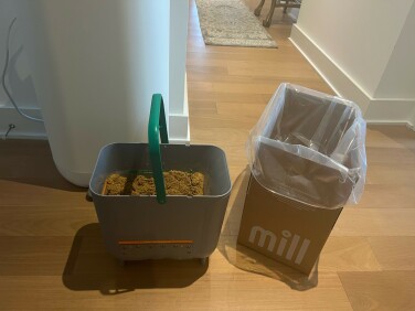 Mill bin bucket and cardboard box with plastic liner sitting on floor