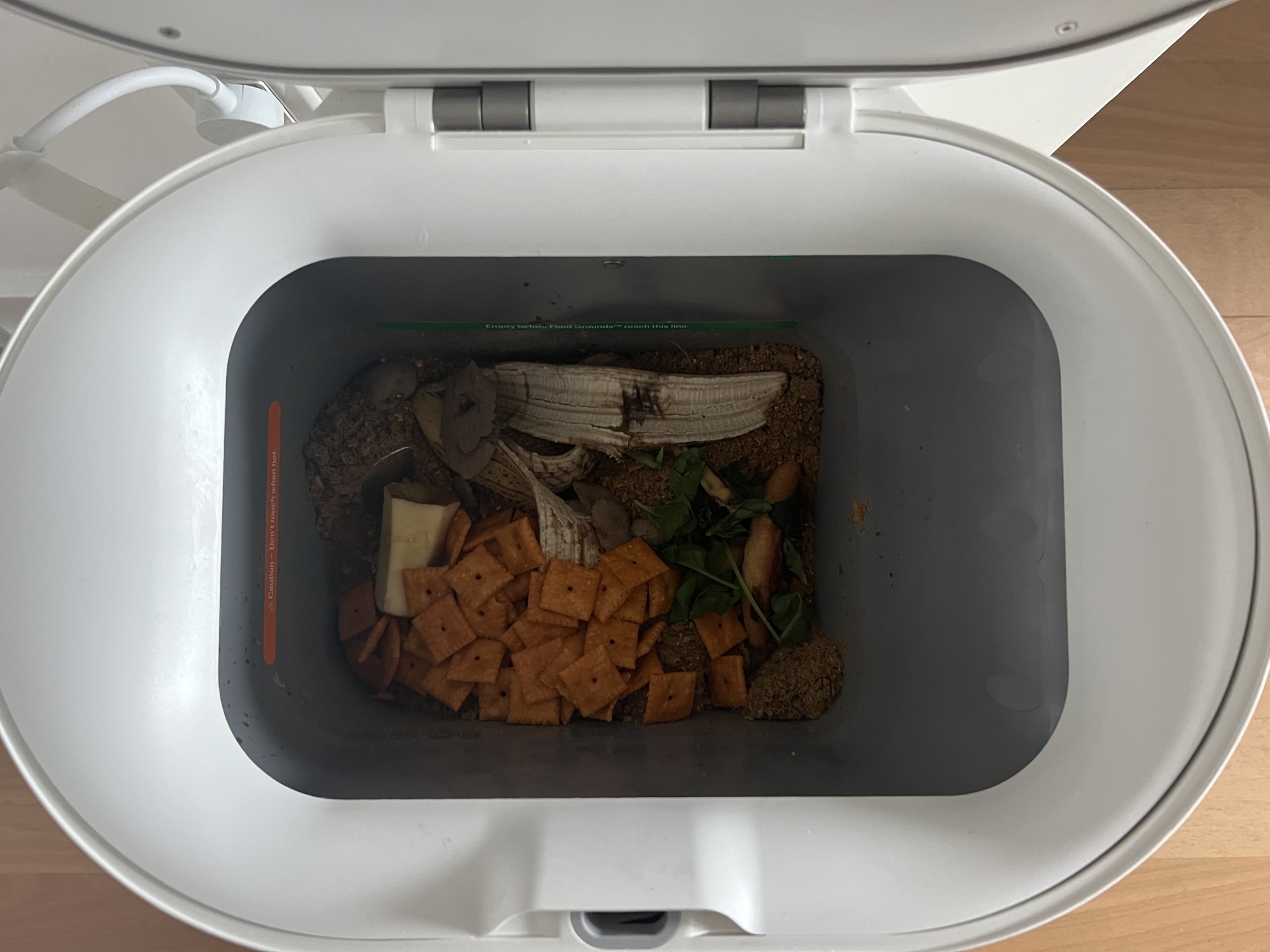 Bucket in Mill bin holding Cheez-Its, a banana peel, an apple core, and pizza crust