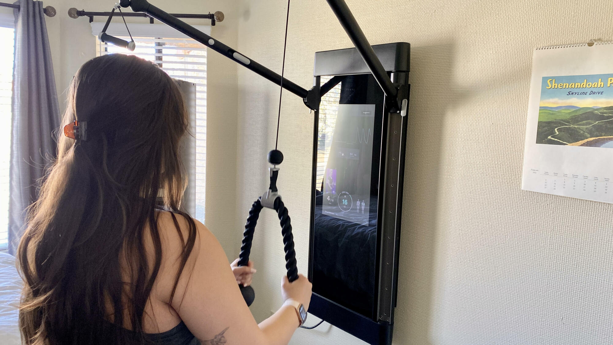 Person with long hair using the Tonal rope smart accessory.