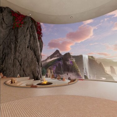 A ridge overlooking a valley and a waterfall. At the edge of the ridge, a fireplace is surrounded by chairs and pillows for lounging.
