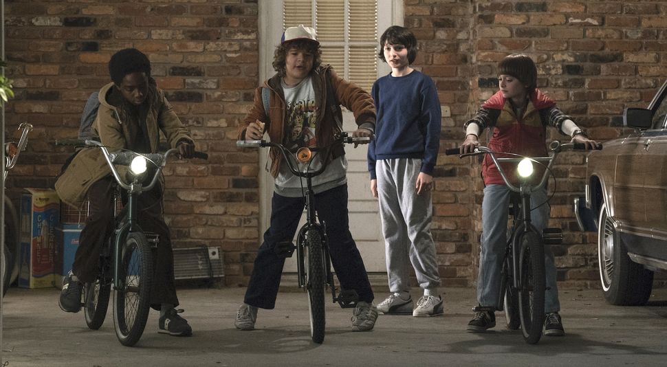 Lucas (Caleb McLaughlin), Dustin (Gaten Matarazzo), Mike (Finn Wolfhard), and Will (Noah Schnapp) would rather be playing Dungeons and Dragons than the real-life version that uproots their lives.